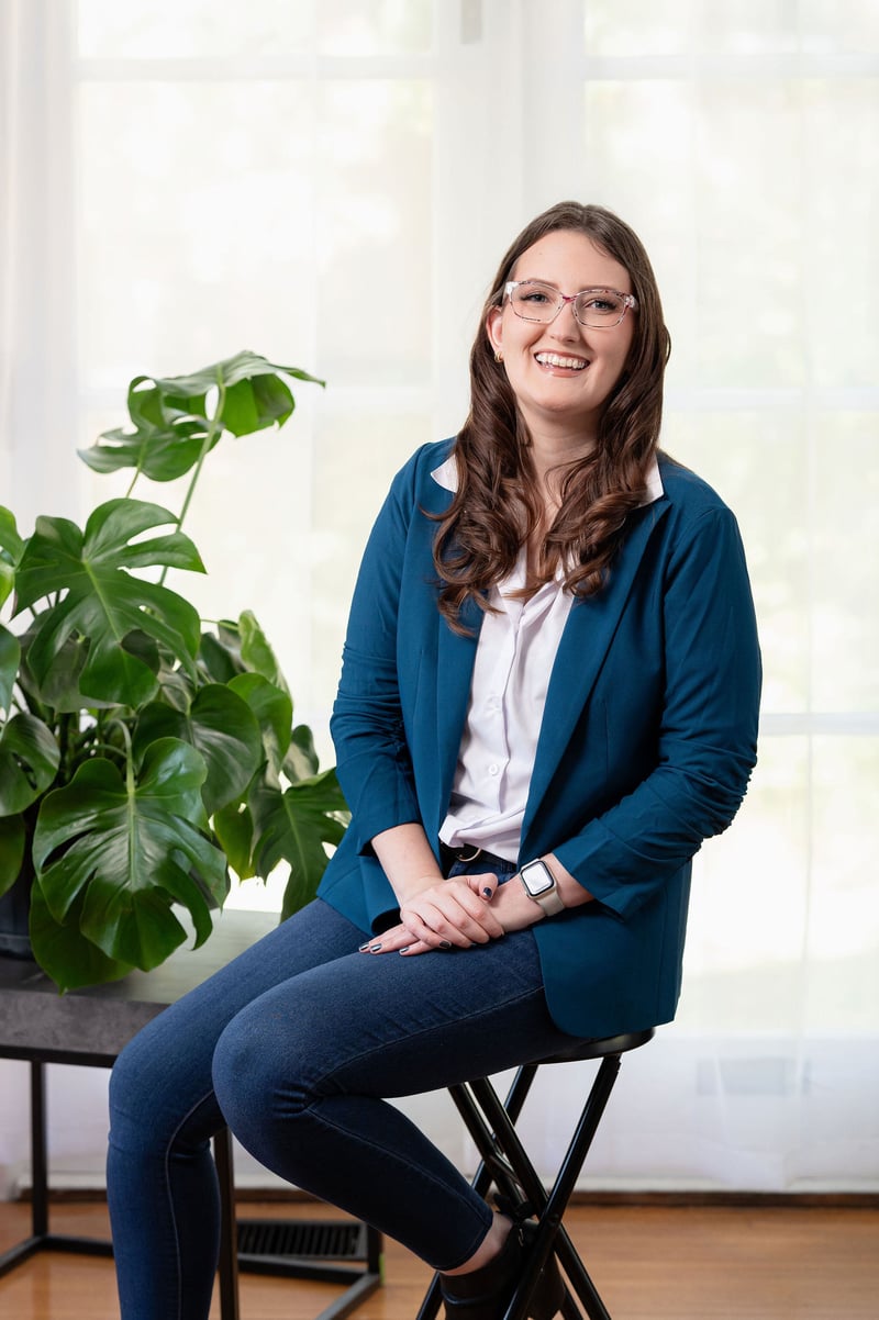 KF sitting on a stool by a plant